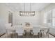 Elegant dining room with coffered ceiling, modern chandelier, and white wainscoting at 111 Stone Park Dr, Wake Forest, NC 27587