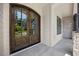 Elegant, arched, glass-paneled double front door with wood finish and stone siding at 111 Stone Park Dr, Wake Forest, NC 27587