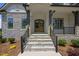 Stone steps leading to an elegant front door with black railing and stone pillars at 111 Stone Park Dr, Wake Forest, NC 27587