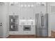 Close-up of gourmet kitchen with double ovens, microwave, and stainless steel refrigerator at 111 Stone Park Dr, Wake Forest, NC 27587