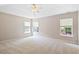 Spacious main bedroom featuring neutral carpeting, a ceiling fan, and large windows at 120 Ryder Cup Cir, Raleigh, NC 27603