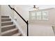 Bright and airy room featuring a staircase, large windows, and neutral carpeting at 120 Ryder Cup Cir, Raleigh, NC 27603