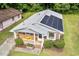 Charming home featuring a well-manicured lawn, solar panels, and a welcoming front porch at 1207 Grant St, Durham, NC 27701
