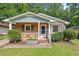 Charming brick home with a cozy front porch, a garden box, and lush landscaping at 1207 Grant St, Durham, NC 27701