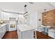 A kitchen showcasing white and grey cabinets with a center island with marbled countertop and wood flooring at 1207 Grant St, Durham, NC 27701