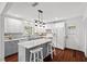 This kitchen boasts gray and white cabinets, marble countertops, and a central island with barstool seating at 1207 Grant St, Durham, NC 27701