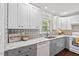 Bright kitchen with gray and white cabinetry, stainless steel appliances and unique backsplash at 1207 Grant St, Durham, NC 27701
