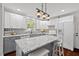 An open kitchen featuring gray and white cabinets, stylish backsplash and modern lighting at 1207 Grant St, Durham, NC 27701