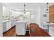 Bright eat-in kitchen featuring gray cabinets, an island with bar seating, and updated countertops and backsplash at 1207 Grant St, Durham, NC 27701