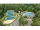 Aerial view of community amenities, featuring tennis courts, a swimming pool, and ample parking at 12117 Inglehurst Dr, Raleigh, NC 27613