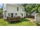 Spacious backyard with a wooden deck, lush lawn, and a charming storage shed at 12117 Inglehurst Dr, Raleigh, NC 27613