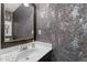 Stylish powder room with a framed mirror and decorative wall texture at 12117 Inglehurst Dr, Raleigh, NC 27613
