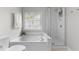 A bright bathroom featuring a soaking tub and a glass-enclosed shower with modern fixtures at 12117 Inglehurst Dr, Raleigh, NC 27613