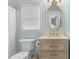 Stylish bathroom with light blue walls, a decorative mirror, and classic fixtures at 12117 Inglehurst Dr, Raleigh, NC 27613