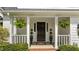 Inviting front porch with hanging ferns and manicured shrubbery at 12117 Inglehurst Dr, Raleigh, NC 27613