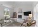 Bright and airy living room featuring a fireplace, large windows, and stylish decor at 12117 Inglehurst Dr, Raleigh, NC 27613