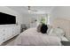 Airy bedroom with a large bed, white furniture, ceiling fan, and view of the outdoors at 12117 Inglehurst Dr, Raleigh, NC 27613
