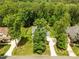 Aerial view of a home with large lawn and mature trees, featuring a three car driveway at 12216 Kyle Abbey Ln, Raleigh, NC 27613