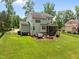 Expansive backyard features lush green lawn, a cozy fire pit area, and a relaxing hot tub for outdoor enjoyment at 12216 Kyle Abbey Ln, Raleigh, NC 27613