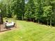 Lush, expansive backyard featuring a relaxing hot tub, inviting fire pit, and well-maintained green lawn at 12216 Kyle Abbey Ln, Raleigh, NC 27613