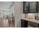 Stylish bar area featuring granite countertops, glass-front cabinets, and convenient access to the kitchen at 12216 Kyle Abbey Ln, Raleigh, NC 27613
