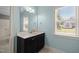Upstairs bathroom featuring a blue color scheme, a black vanity, and natural light at 12216 Kyle Abbey Ln, Raleigh, NC 27613