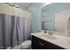 This bathroom features a shower with grey curtain, a toilet, and a vanity with sink and mirror at 12216 Kyle Abbey Ln, Raleigh, NC 27613
