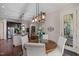Charming dining area with a wood table, white chairs, stylish lighting, and a view to the kitchen at 12216 Kyle Abbey Ln, Raleigh, NC 27613