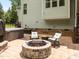 Cozy outdoor patio with a stone fire pit, comfortable seating, and a relaxing hot tub for ultimate backyard enjoyment at 12216 Kyle Abbey Ln, Raleigh, NC 27613