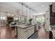 Open-concept kitchen with a granite island, seating, stainless steel appliances, and a view to the living room at 12216 Kyle Abbey Ln, Raleigh, NC 27613