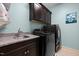 Laundry room with ample cabinet space, modern washer and dryer, and a convenient utility sink at 12216 Kyle Abbey Ln, Raleigh, NC 27613