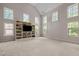 Large, open living room with lots of windows, high ceilings and a built-in bookcase with television at 12216 Kyle Abbey Ln, Raleigh, NC 27613