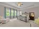 Spacious main bedroom boasts an ornate bed frame, tray ceilings, windows, and an abundance of natural light at 12216 Kyle Abbey Ln, Raleigh, NC 27613