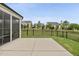 View of screened in back patio with black fence and green space in a residential neighborhood at 123 Turnstone Dr, Durham, NC 27703