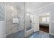 Spa-like bathroom featuring blue tile flooring, glass enclosed shower and view into the bedroom at 123 Turnstone Dr, Durham, NC 27703