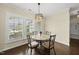 Cozy dining area with a round table, four chairs, and natural light from the windows at 123 Turnstone Dr, Durham, NC 27703