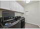 Laundry room equipped with modern washer, dryer, overhead cabinets, and sink at 123 Turnstone Dr, Durham, NC 27703