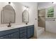 Bathroom featuring double sinks, neutral paint and tile, and natural lighting at 124 Lord Ashley Rd, Raleigh, NC 27610