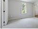 Bedroom with neutral carpet and paint, natural light, and views of the trees at 124 Lord Ashley Rd, Raleigh, NC 27610