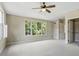 Bright bedroom with large windows offering a view, neutral walls, and ceiling fan at 124 Lord Ashley Rd, Raleigh, NC 27610