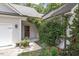 Covered entry featuring a quaint, rustic wood door and lush, mature landscaping at 124 Lord Ashley Rd, Raleigh, NC 27610