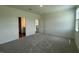 Spacious bedroom featuring plush carpeting, a doorway to the bathroom, and abundant natural light at 125 Fraiser Fir Way, Lillington, NC 27546