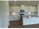 Modern kitchen features white cabinets, granite countertops, stainless steel appliances, and a functional island at 125 Fraiser Fir Way, Lillington, NC 27546