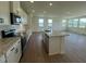 Open kitchen featuring white cabinets, stainless steel appliances, granite countertops, and an island open to the dining room at 125 Fraiser Fir Way, Lillington, NC 27546