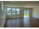 Bright living room featuring a sliding glass door, large windows, and modern recessed lighting at 125 Fraiser Fir Way, Lillington, NC 27546