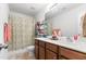Well-lit bathroom features double sink vanity, tiled floor, and patterned shower curtain at 131 Botanical Ct, Bunnlevel, NC 28323