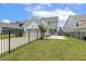 Backyard showing lawn, black fence, and the rear of the light blue home at 141 Beldenshire Way, Holly Springs, NC 27540