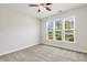 Spacious bedroom with multiple windows providing natural light and neutral carpeting at 141 Beldenshire Way, Holly Springs, NC 27540
