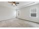 Carpeted bedroom with ceiling fan, recessed ceiling, and two windows at 141 Beldenshire Way, Holly Springs, NC 27540