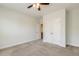 Bright bedroom featuring neutral carpet, ceiling fan, and double door closet for ample storage at 141 Beldenshire Way, Holly Springs, NC 27540